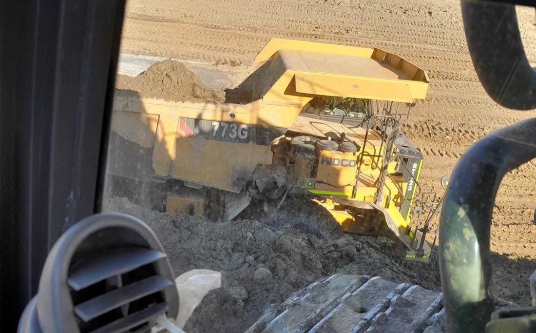 Open utility trench with concrete catch basin set to grade on a prepared site